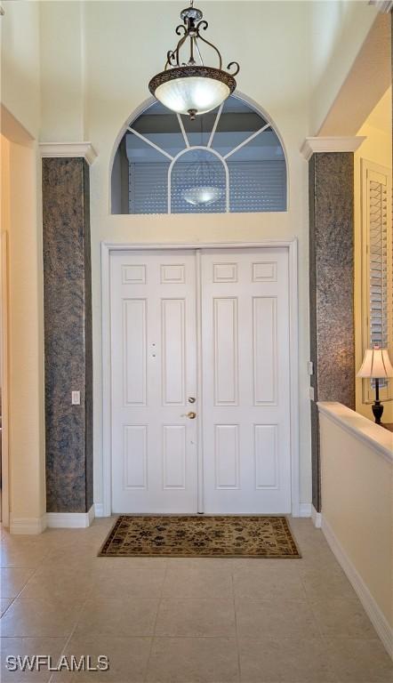 foyer featuring tile patterned flooring and a towering ceiling