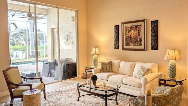 living room with light tile patterned floors, a wealth of natural light, and ceiling fan