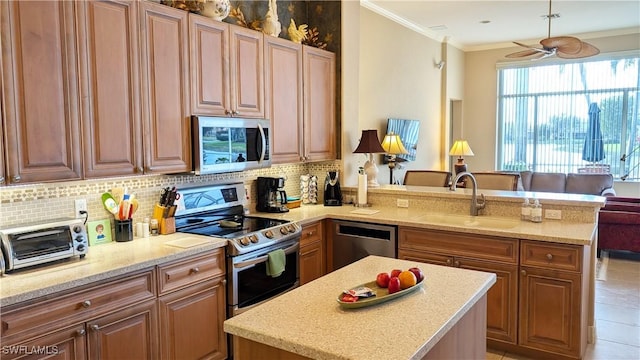 kitchen featuring kitchen peninsula, tasteful backsplash, stainless steel appliances, ceiling fan, and sink