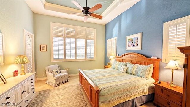 bedroom featuring a tray ceiling, ceiling fan, and ornamental molding