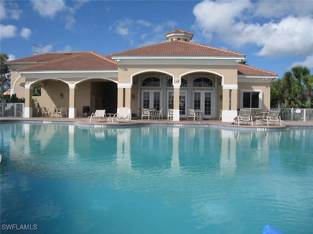 back of property with a community pool, a patio area, and french doors