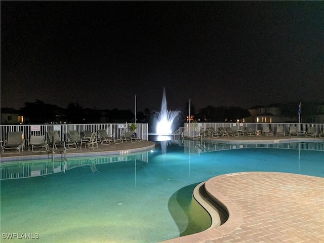 view of pool at twilight