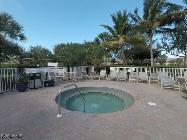 view of swimming pool featuring a patio and a hot tub