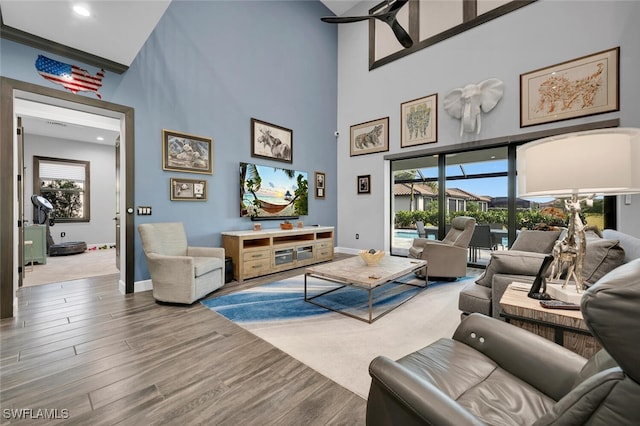 living room with a high ceiling and wood-type flooring