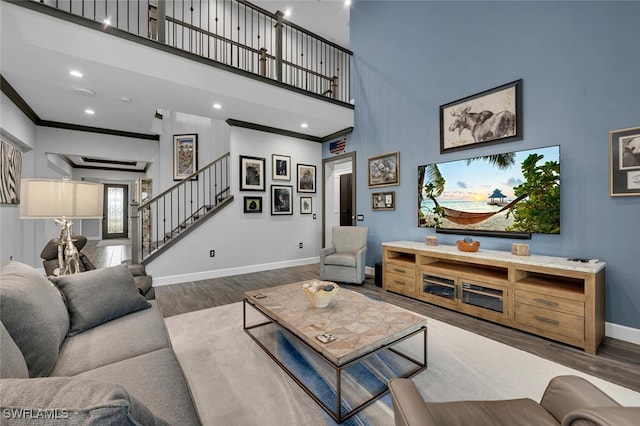 living room featuring a high ceiling, crown molding, and dark hardwood / wood-style flooring