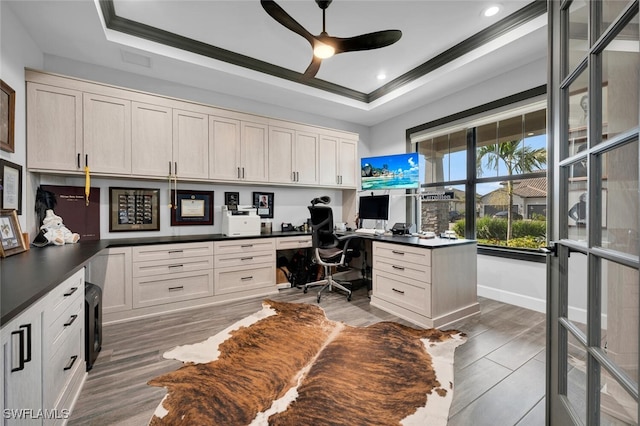 office space featuring ornamental molding, a raised ceiling, ceiling fan, and built in desk