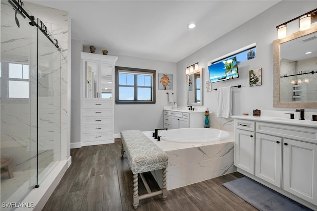 bathroom with shower with separate bathtub, vanity, and hardwood / wood-style flooring