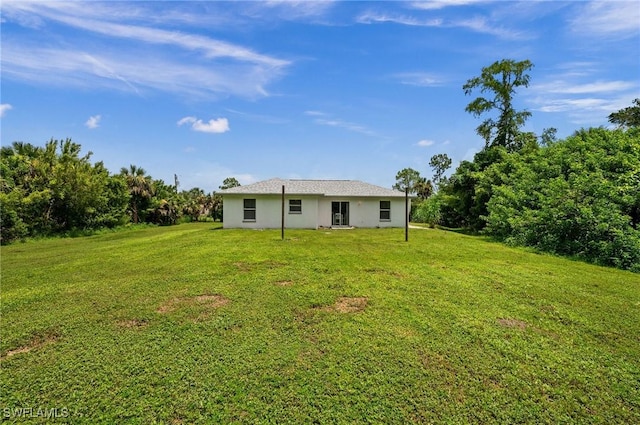 rear view of property with a yard