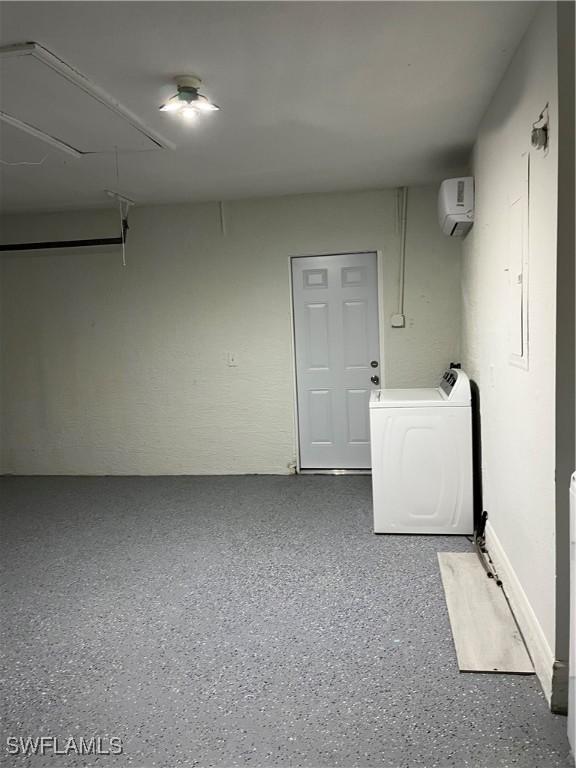 laundry area featuring an AC wall unit and washer / dryer