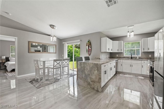 kitchen with white cabinets, pendant lighting, and light stone counters