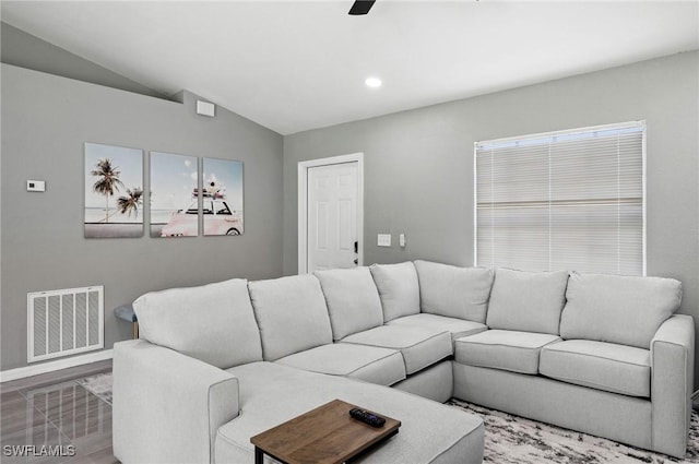 living room featuring hardwood / wood-style floors, ceiling fan, and vaulted ceiling