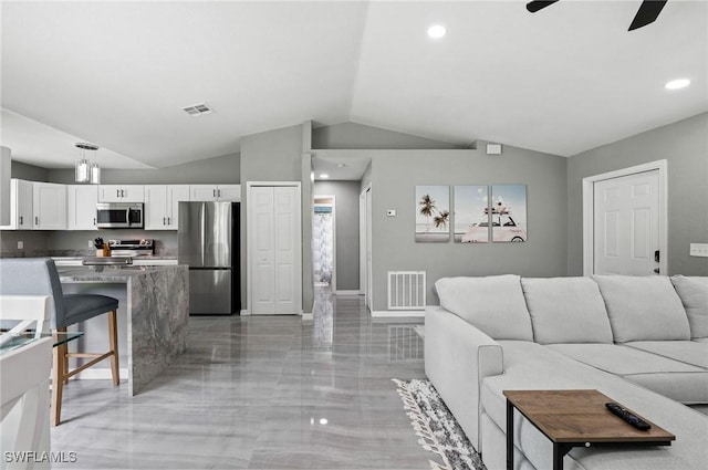 living room featuring ceiling fan and lofted ceiling