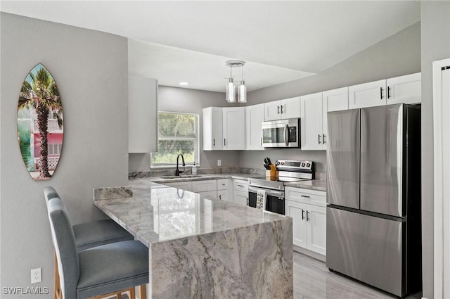 kitchen with kitchen peninsula, appliances with stainless steel finishes, sink, white cabinets, and hanging light fixtures