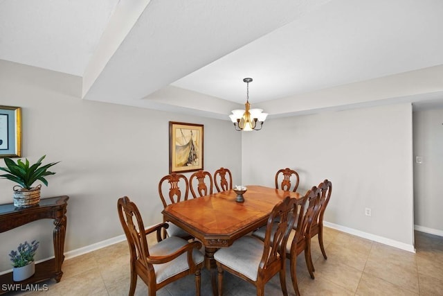 dining room with a tray ceiling, light tile patterned floors, and a notable chandelier