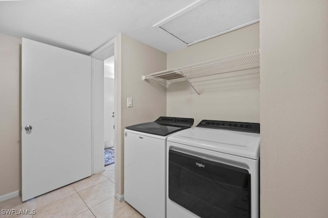 clothes washing area featuring washing machine and clothes dryer and light tile patterned flooring