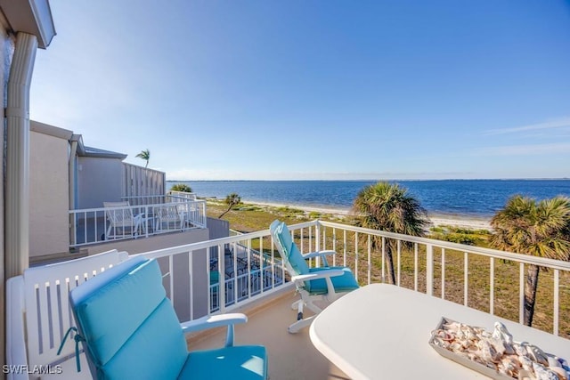 balcony featuring a beach view and a water view