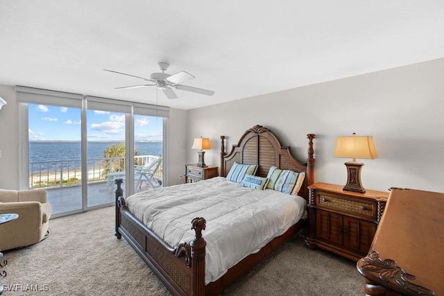 carpeted bedroom featuring ceiling fan, expansive windows, a water view, and access to outside