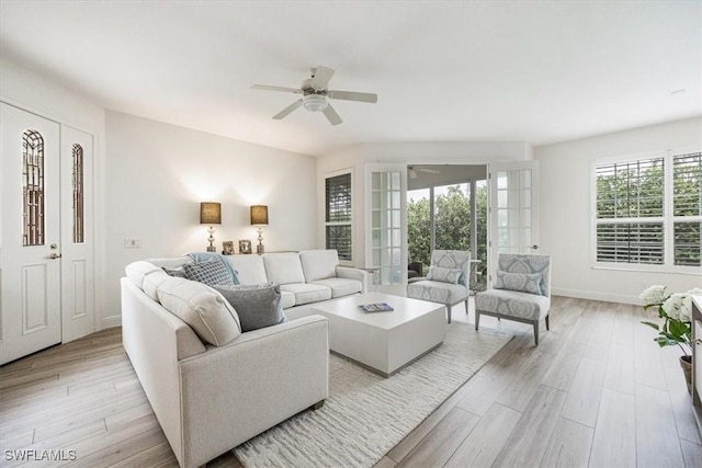 living room with light hardwood / wood-style flooring, french doors, and ceiling fan