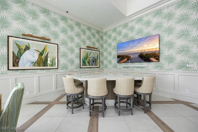 dining space featuring light tile patterned flooring, indoor bar, and ornamental molding