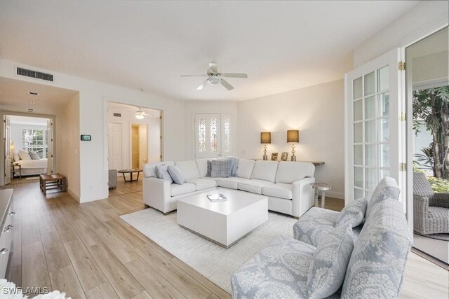 living room with ceiling fan and light hardwood / wood-style floors