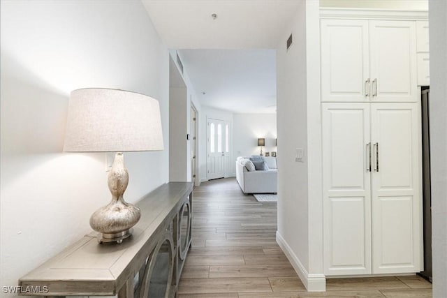 corridor with light hardwood / wood-style floors