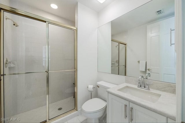 bathroom featuring vanity, toilet, and walk in shower