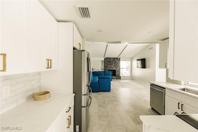 kitchen with white cabinetry, a fireplace, and appliances with stainless steel finishes