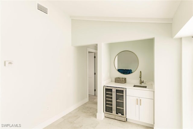 bar with white cabinets, wine cooler, lofted ceiling, and sink