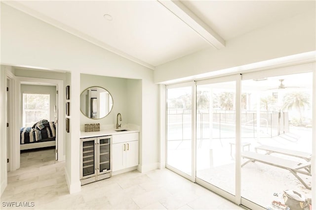 interior space with lofted ceiling with beams, white cabinetry, sink, and wine cooler