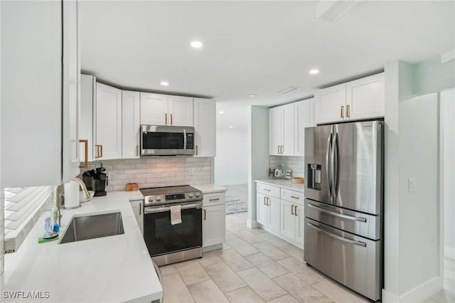 1298 Par View Dr, Sanibel, FL 33957 - kitchen with appliances with stainless steel finishes, a sink, backsplash, light countertops, and white cabinets