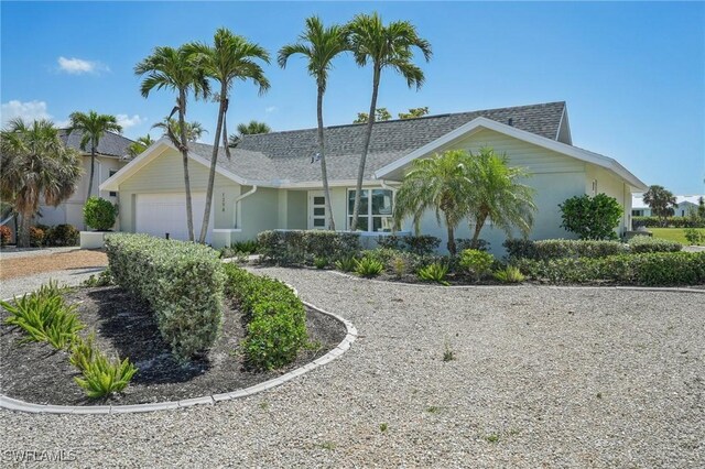1298 Par View Dr, Sanibel, FL 33957 - ranch-style house with a garage, stucco siding, driveway, and roof with shingles