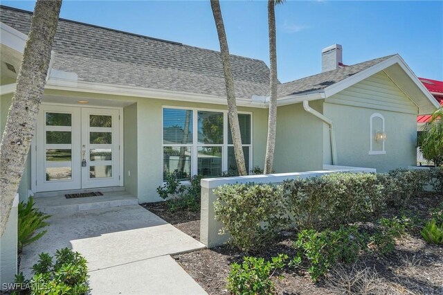 1298 Par View Dr, Sanibel, FL 33957 - doorway to property with french doors, stucco siding, a shingled roof, and a chimney