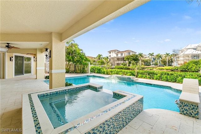 view of swimming pool with pool water feature, ceiling fan, a patio area, and an in ground hot tub