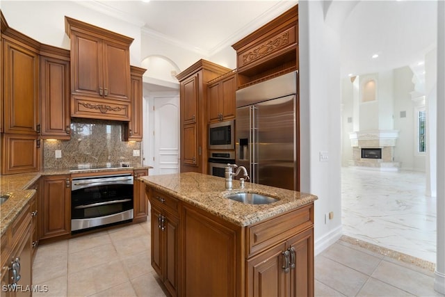 kitchen with sink, light stone counters, backsplash, built in appliances, and crown molding