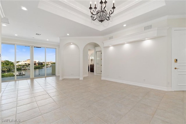 tiled spare room featuring a water view, ornamental molding, and a tray ceiling