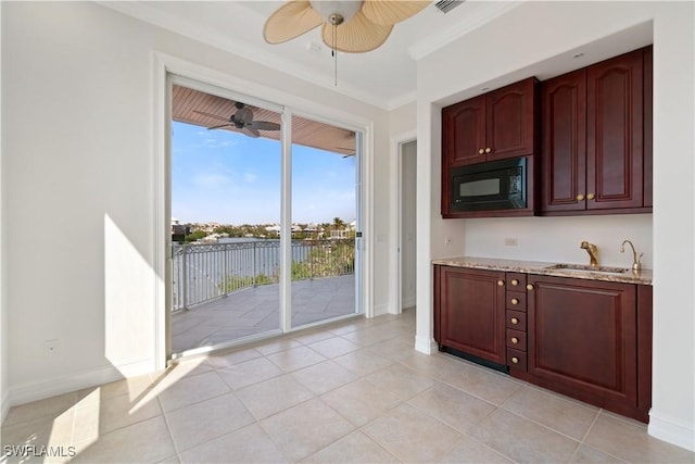 kitchen with light tile patterned floors, black microwave, crown molding, and sink