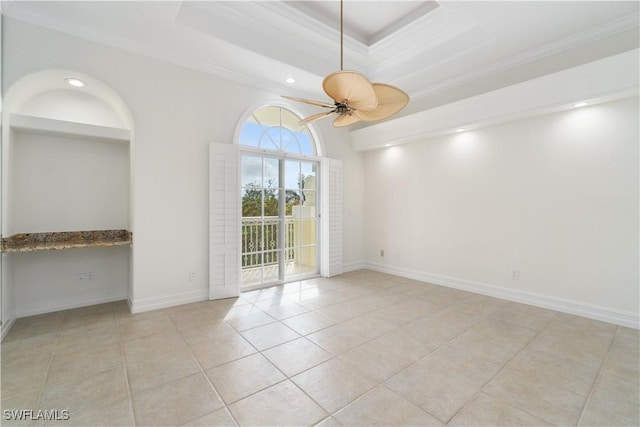 unfurnished room featuring ceiling fan, light tile patterned flooring, crown molding, and a tray ceiling