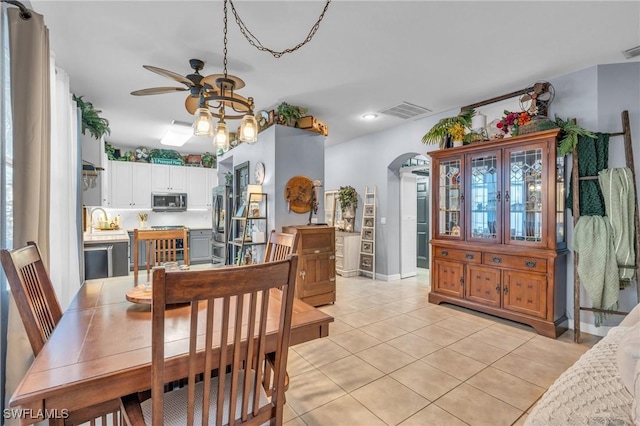 tiled dining room featuring ceiling fan and sink