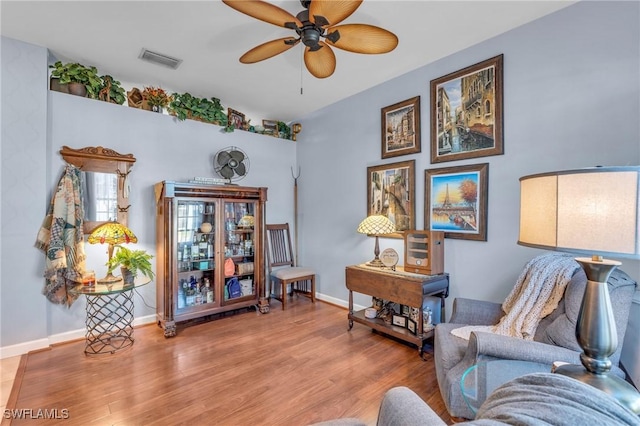 living area with ceiling fan and wood-type flooring