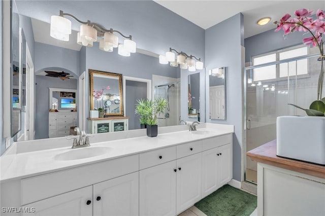 bathroom with ceiling fan, walk in shower, and vanity