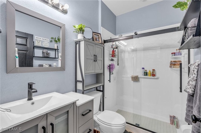 bathroom with vanity, toilet, and a shower with shower door