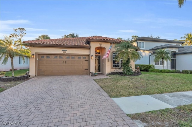 mediterranean / spanish house featuring a front yard and a garage