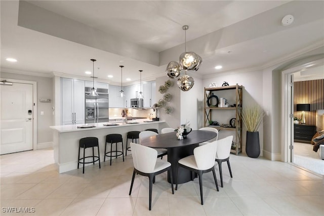 dining area with crown molding and light tile patterned floors