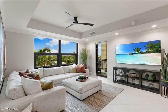 living room featuring a raised ceiling and ceiling fan