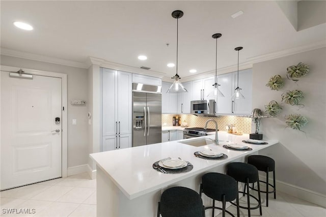 kitchen with a kitchen bar, sink, hanging light fixtures, kitchen peninsula, and stainless steel appliances