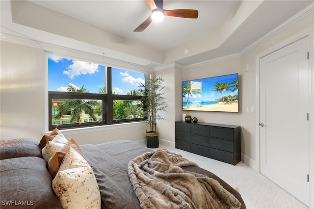 carpeted bedroom with ceiling fan and a tray ceiling