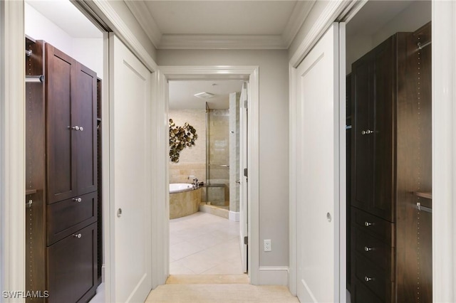 corridor featuring crown molding and light tile patterned floors