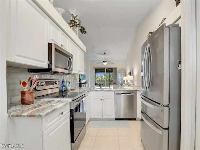 kitchen featuring backsplash, stainless steel appliances, white cabinetry, and ceiling fan