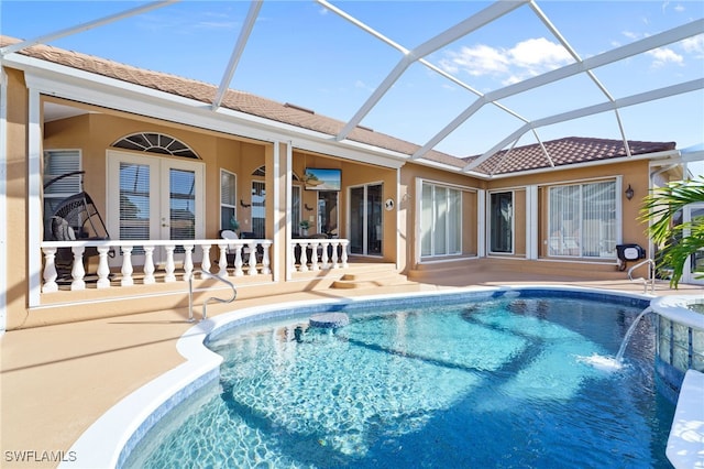 view of swimming pool featuring glass enclosure, pool water feature, french doors, and a patio