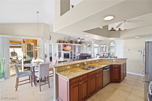 kitchen with stainless steel appliances, ceiling fan, sink, light tile patterned floors, and decorative light fixtures